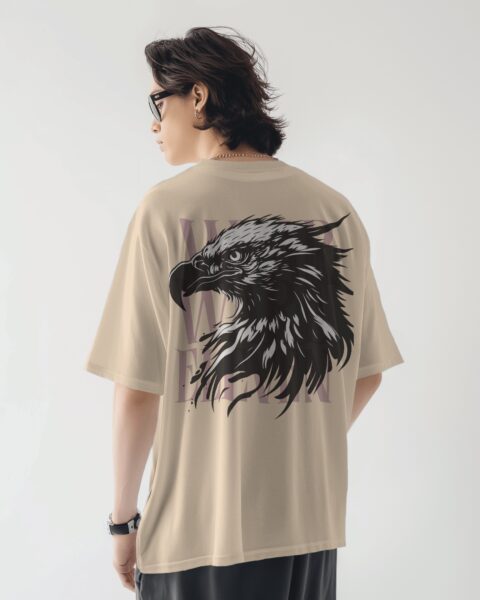 Person wearing a beige t-shirt with an eagle design on the back against a white background