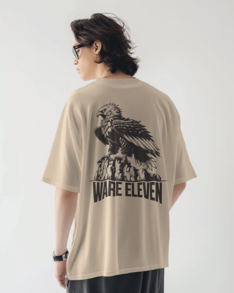 Person wearing a beige t-shirt with an eagle graphic and 'WARE ELEVEN' text on the back.