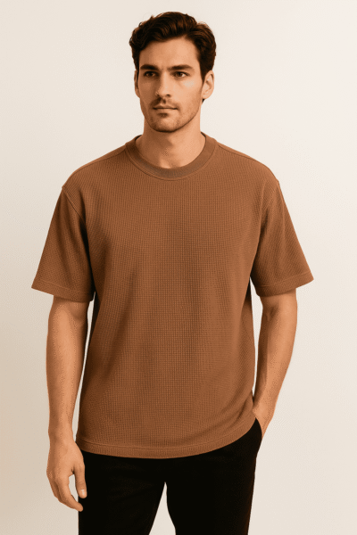 Man wearing a brown t-shirt against a beige background